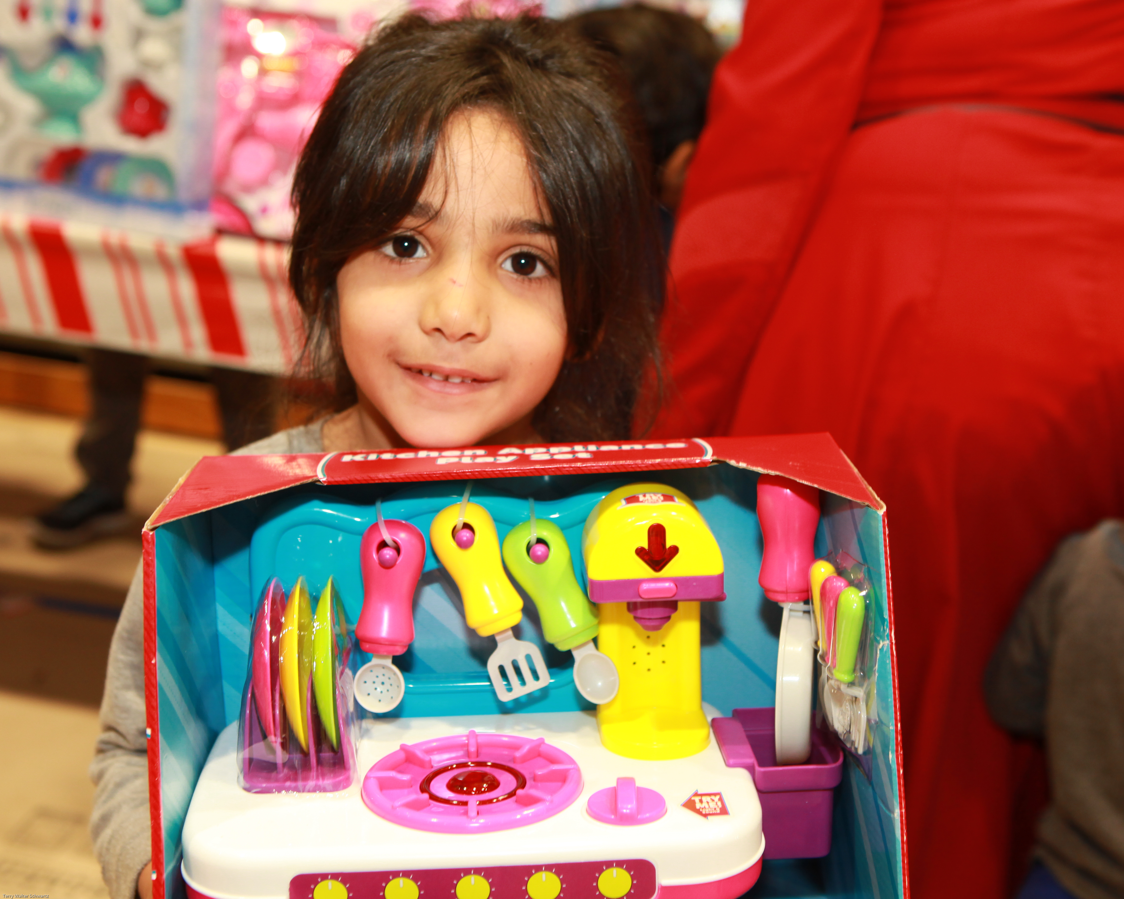 Smiling girl holding a toy cooking set